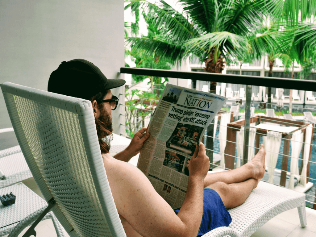 An-image-showing-a-man-reading-a-newspaper-on-a-balcony-in-5-star-luxury-in-Phuket