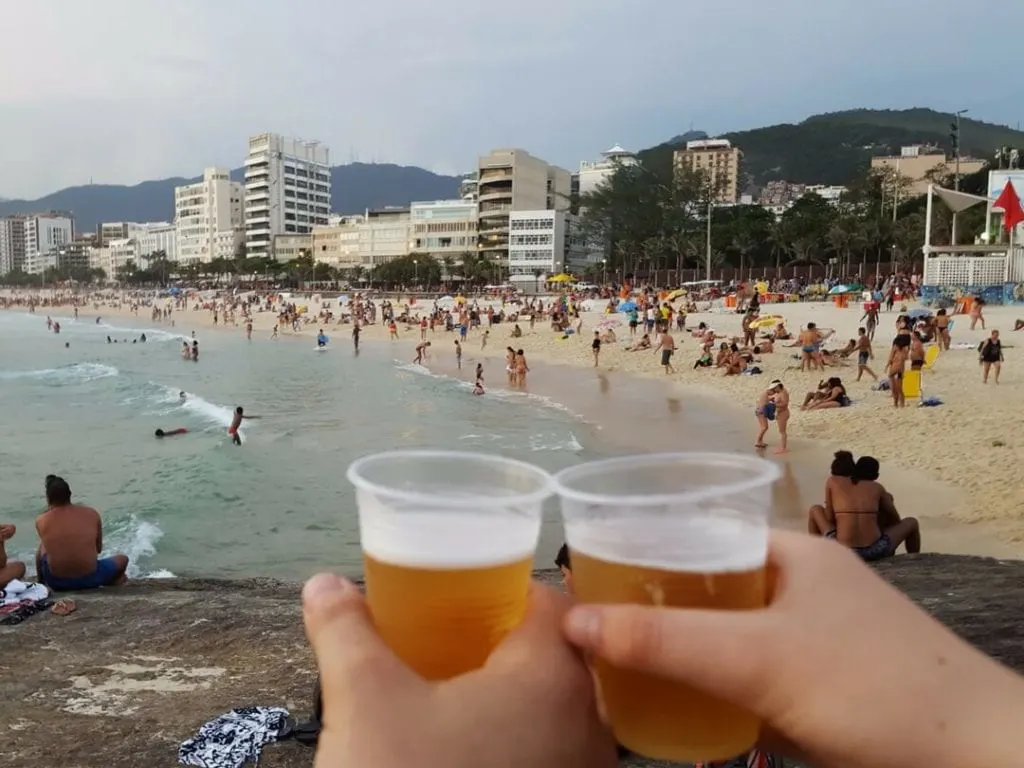 A photo of beers and people at Arpoador Beach, Rio de Janeiro