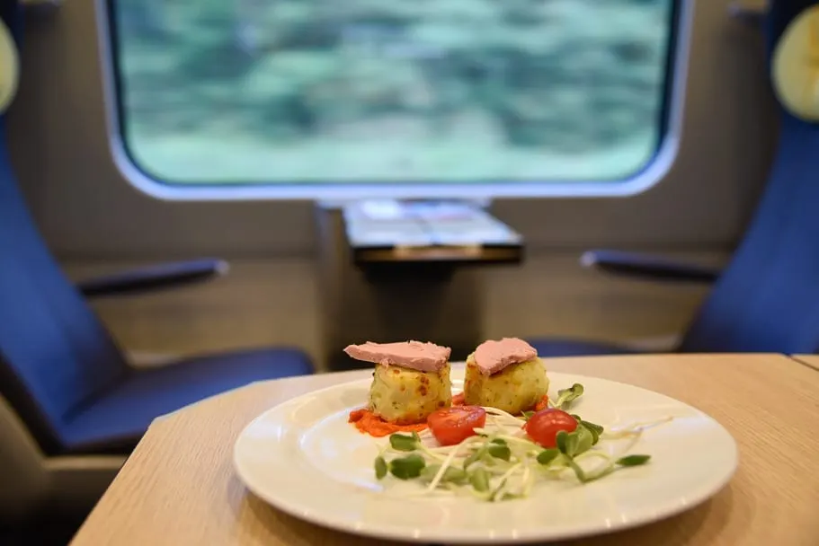 Duck meal on the table of the 1st class carriage with scenery behind on the train from Krakow to Gdansk