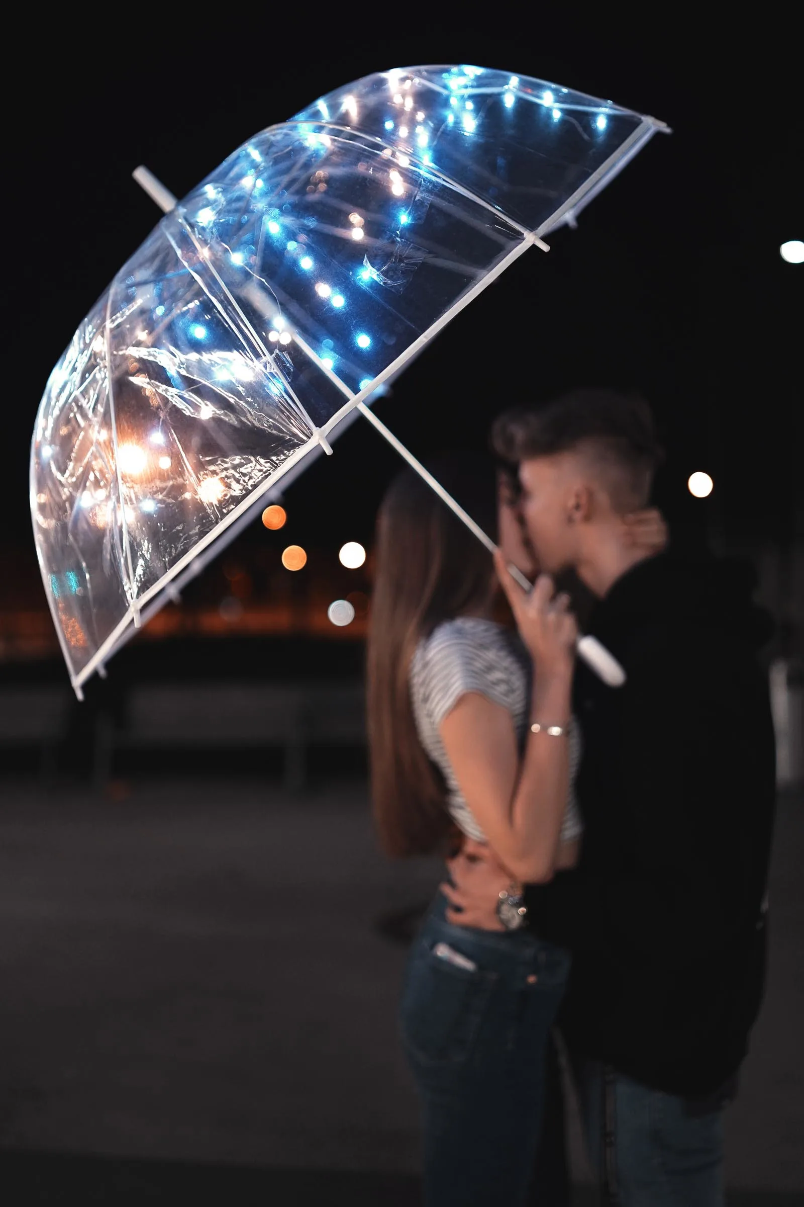 girl-holding-umbrella-kissing-boyfriend-on-a-rainy-day-date