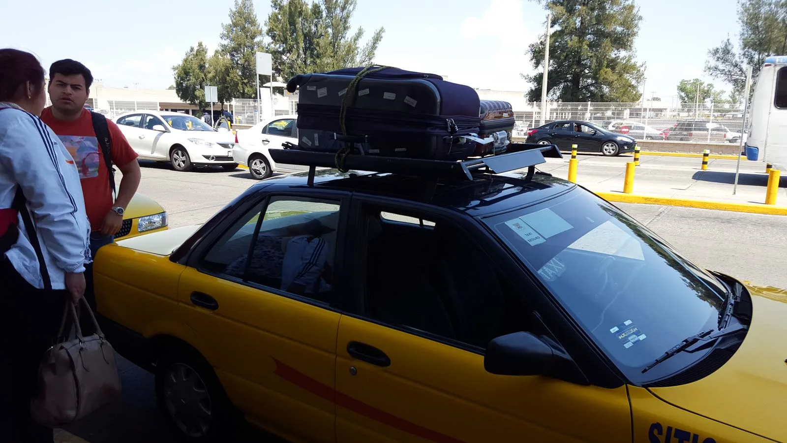 Catching a taxi in Mexico with suitcases on the roof