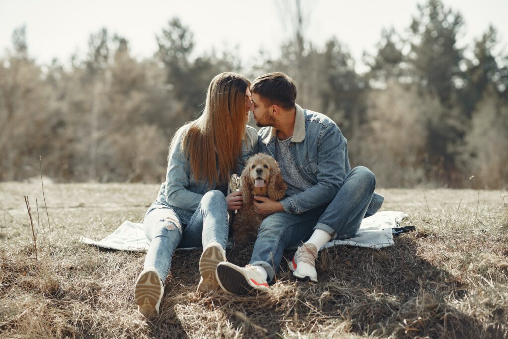 How do I know he loves me? Couple kissing in nature with dog